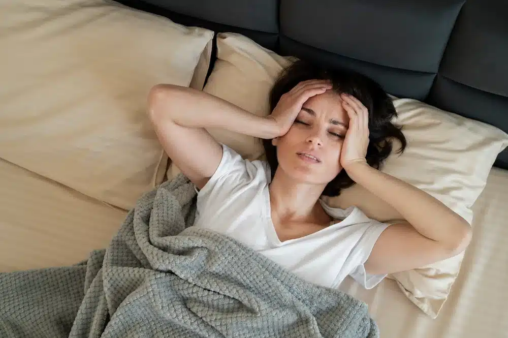 Femme allongée dans son lit souffrant d’insomnie et cherchant le sommeil