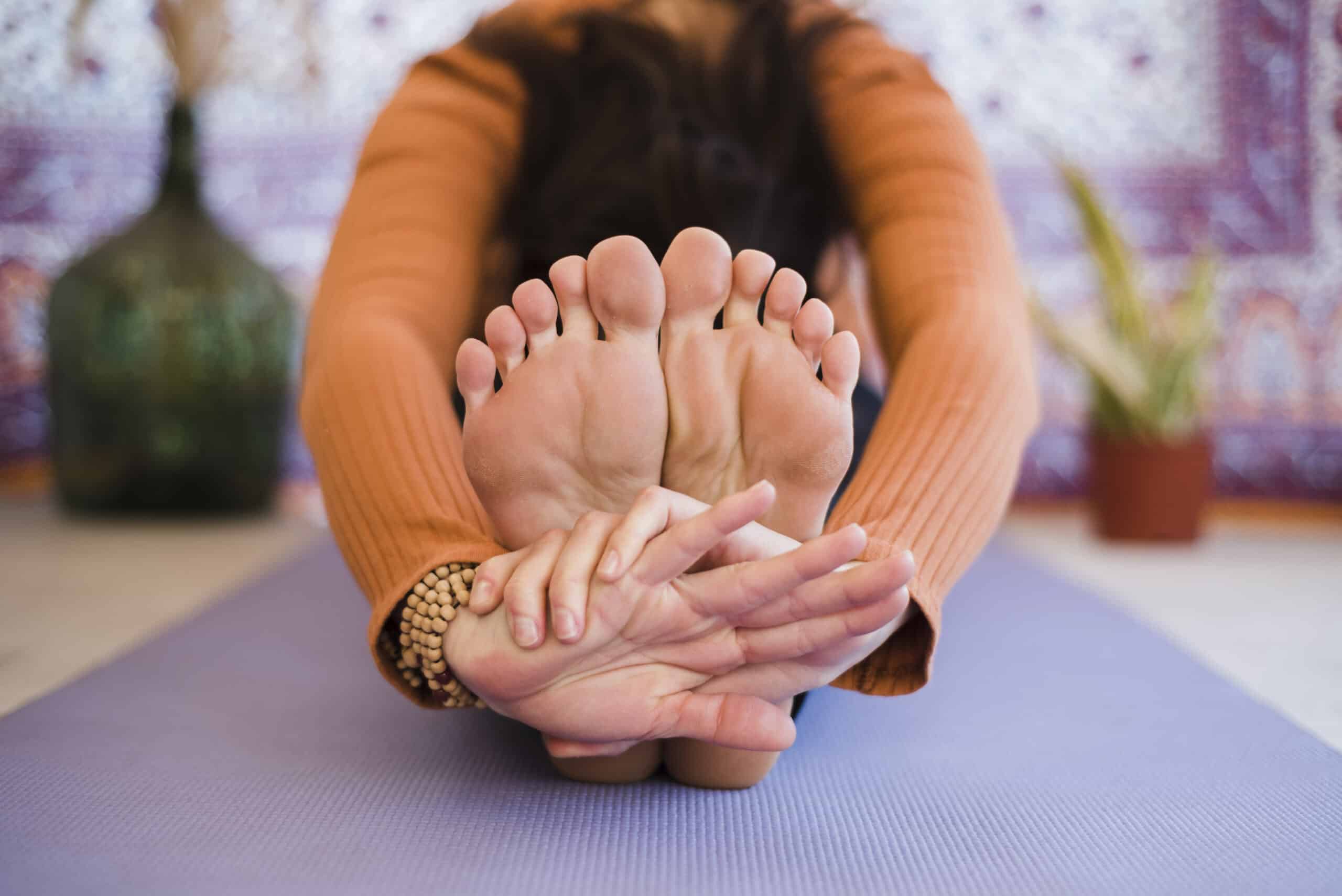 Posture de relaxation et étirement au sol illustrant une séance de sophrologie-des-pieds